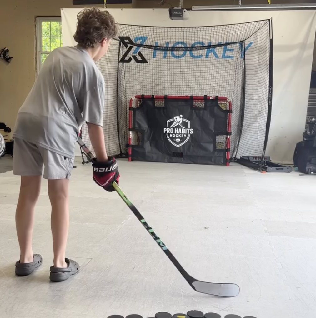 Young player lining up a shot at a Pro Habits Hockey shooting tarp in a garage