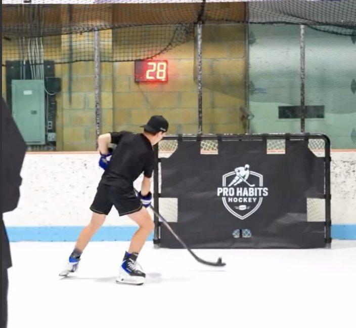 Player on the ice shooting at a Pro Habits Hockey shooting tarp